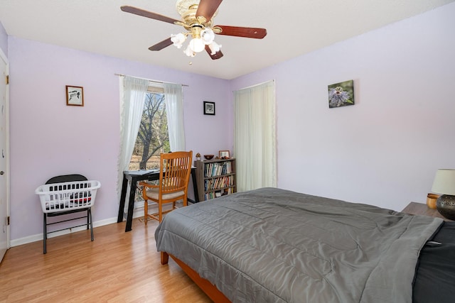 bedroom with ceiling fan, light wood-type flooring, and baseboards