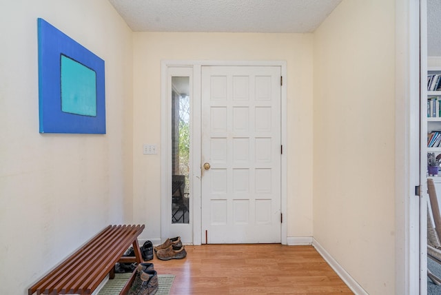 entryway with baseboards, a textured ceiling, and light wood finished floors