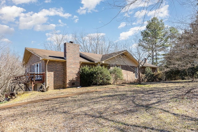 view of home's exterior featuring a chimney and brick siding