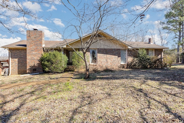 exterior space with a chimney and brick siding