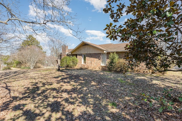 view of property exterior with brick siding and a chimney