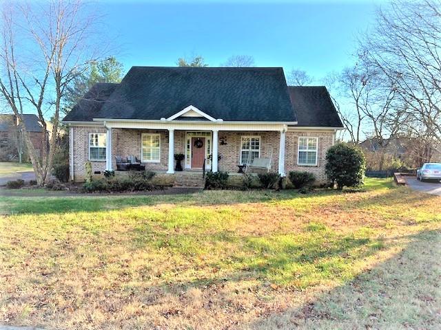 view of front of property with covered porch and a front lawn