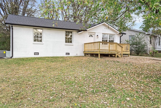 back of property featuring central AC unit, a deck, and a yard