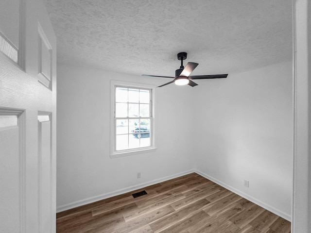 unfurnished room with ceiling fan, hardwood / wood-style floors, and a textured ceiling