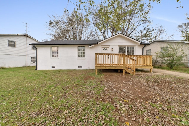 rear view of property featuring a wooden deck and a yard