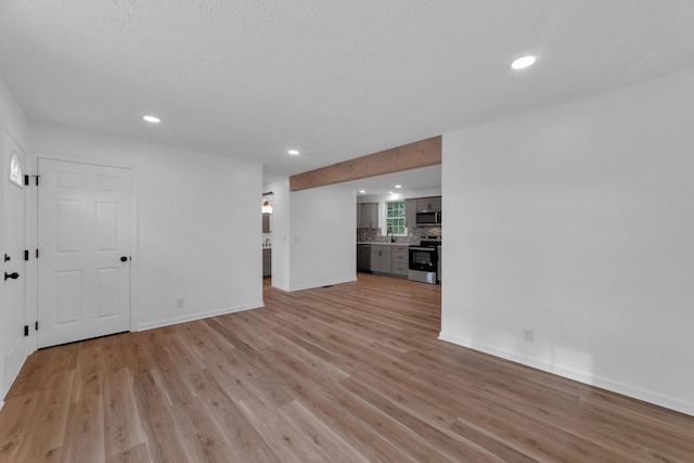 unfurnished living room with sink and light hardwood / wood-style flooring