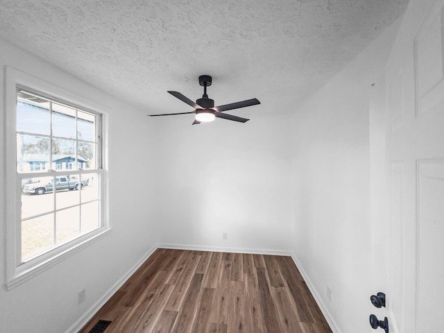 empty room with ceiling fan, dark hardwood / wood-style flooring, and a textured ceiling