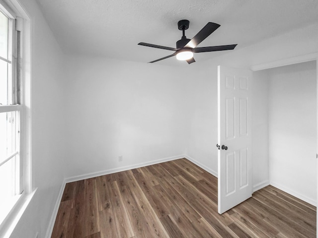 unfurnished room with ceiling fan and dark hardwood / wood-style flooring