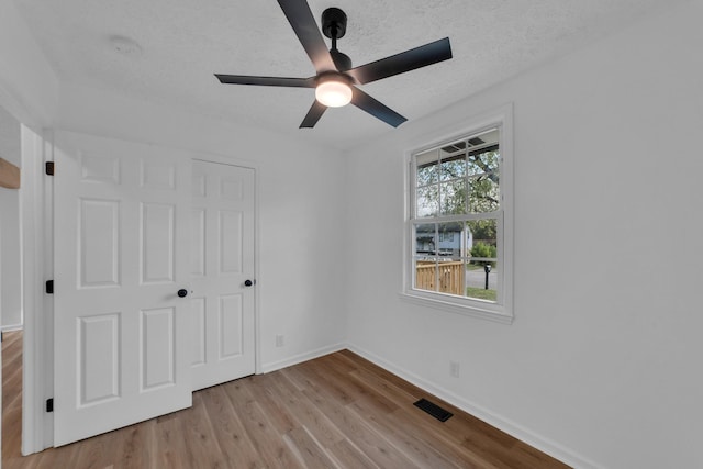 unfurnished bedroom featuring ceiling fan, a closet, and light hardwood / wood-style floors