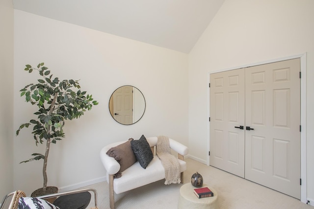 sitting room with light carpet and vaulted ceiling