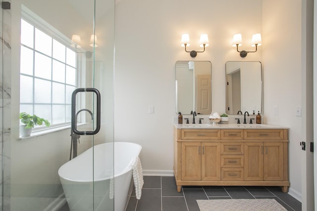 bathroom with tile patterned flooring, a washtub, and vanity