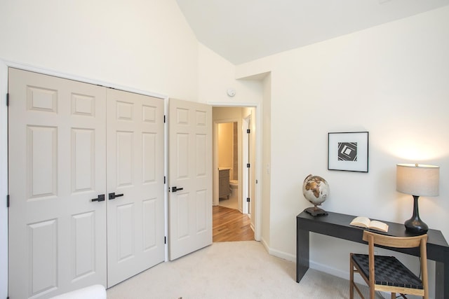 carpeted office space with vaulted ceiling