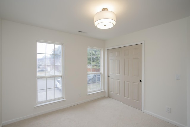 spare room featuring light carpet