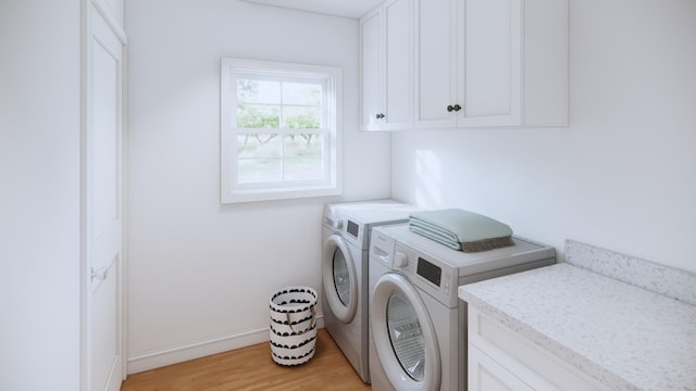 washroom with light hardwood / wood-style floors, cabinets, and washer and clothes dryer