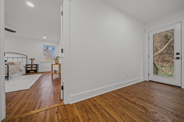 unfurnished bedroom featuring access to exterior, recessed lighting, baseboards, and dark wood-style floors