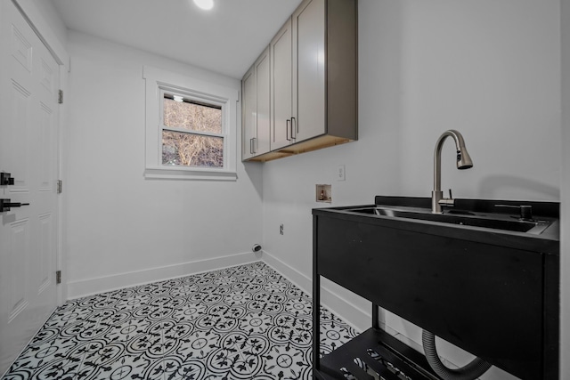 laundry room featuring washer hookup, light tile patterned floors, cabinet space, a sink, and baseboards