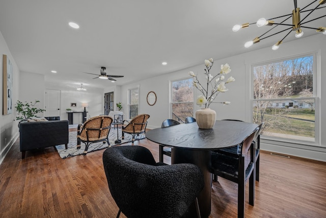 dining area featuring a notable chandelier, visible vents, wood finished floors, and recessed lighting