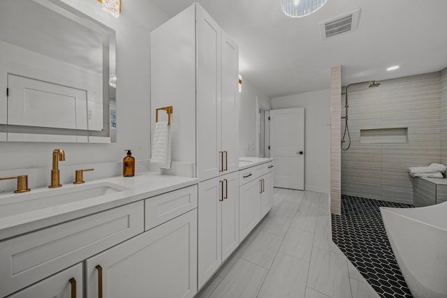 full bath featuring walk in shower, a soaking tub, vanity, and visible vents