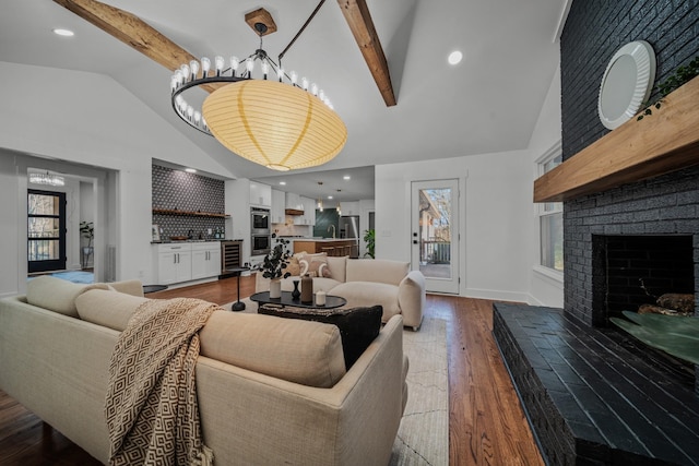 living area with a fireplace, wood finished floors, and beam ceiling