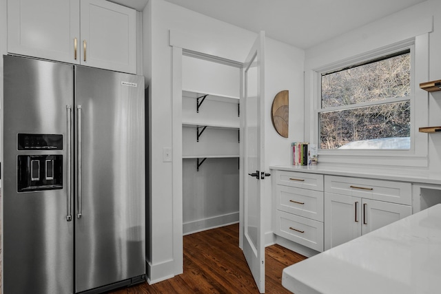 kitchen with light stone counters, dark wood finished floors, open shelves, white cabinets, and high end refrigerator