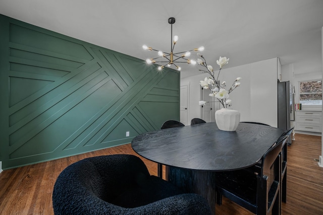 dining room featuring dark wood-style floors and an inviting chandelier