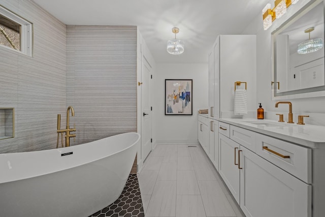 bathroom with a freestanding bath, vanity, and baseboards