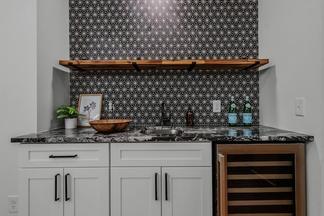 bar featuring beverage cooler, bar, a sink, and decorative backsplash