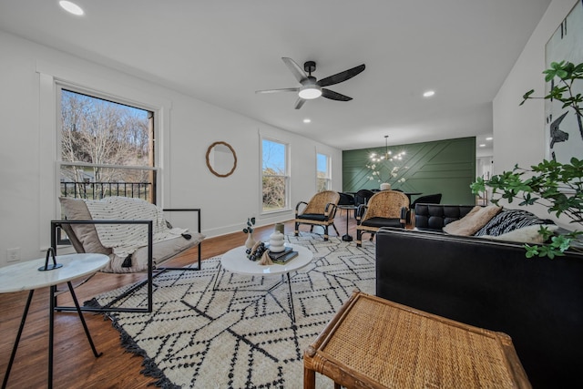 living room featuring baseboards, ceiling fan with notable chandelier, wood finished floors, and recessed lighting