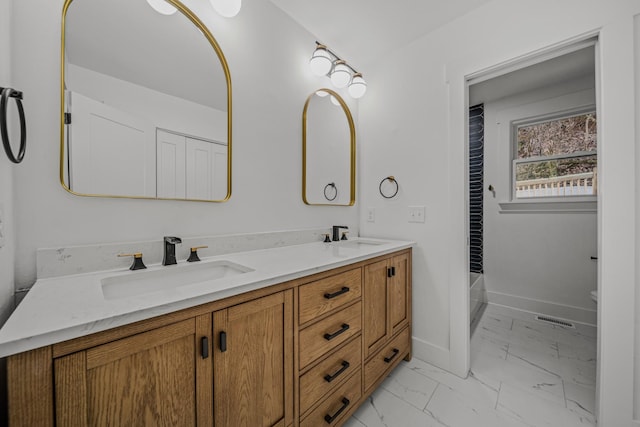 bathroom with double vanity, visible vents, baseboards, marble finish floor, and a sink