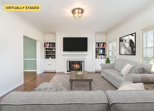 living room featuring dark hardwood / wood-style flooring, built in features, ornamental molding, and a fireplace