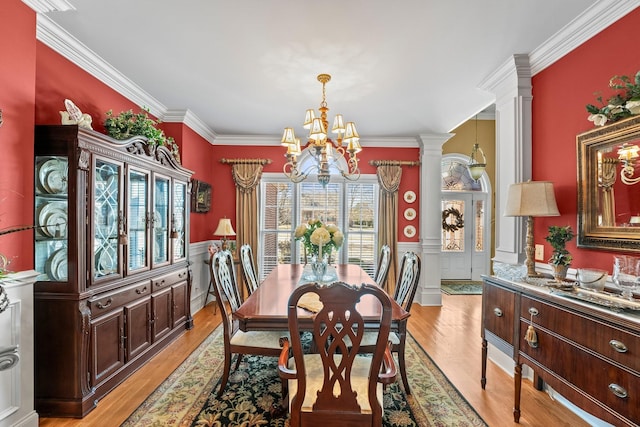 dining room with an inviting chandelier, ornamental molding, light hardwood / wood-style flooring, and decorative columns