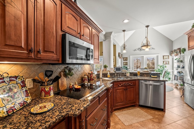 kitchen featuring lofted ceiling, decorative light fixtures, backsplash, appliances with stainless steel finishes, and dark stone counters