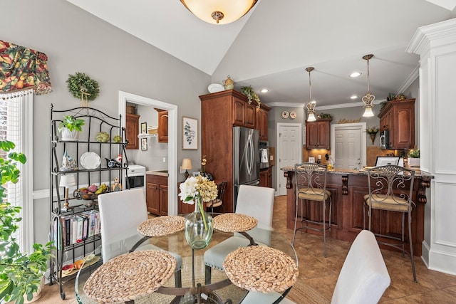 dining space with high vaulted ceiling, tile patterned floors, and ornamental molding