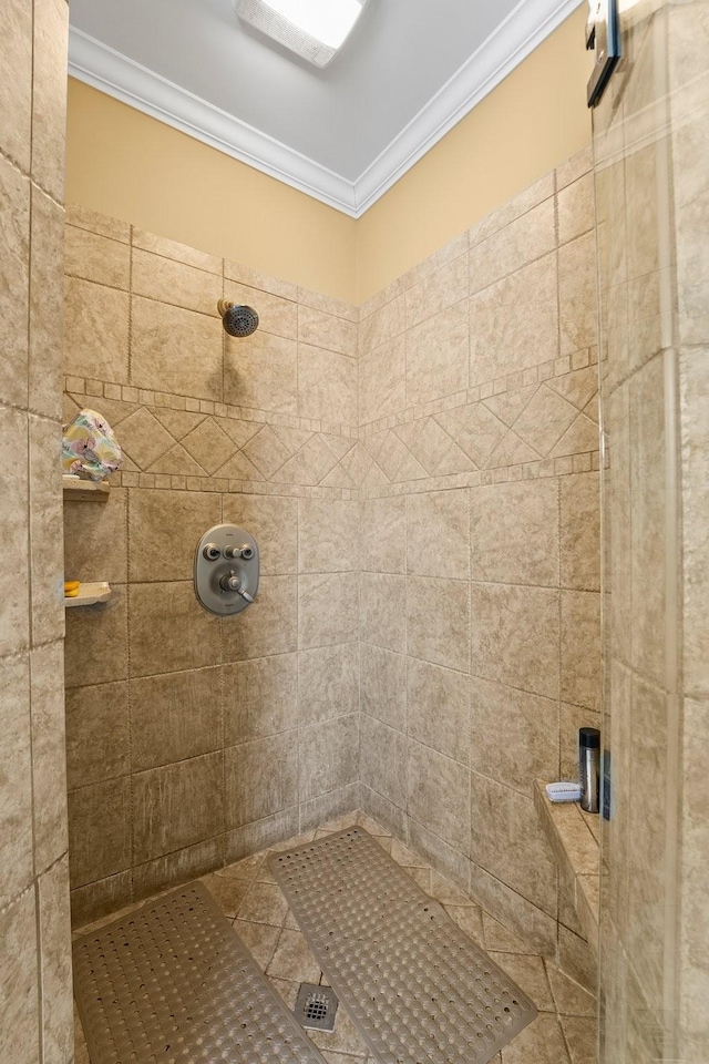 bathroom featuring tile patterned flooring, tiled shower, and ornamental molding