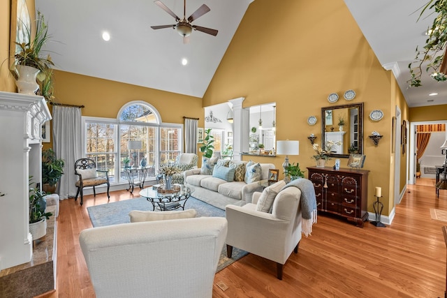 living room featuring high vaulted ceiling, a high end fireplace, light hardwood / wood-style flooring, and ceiling fan