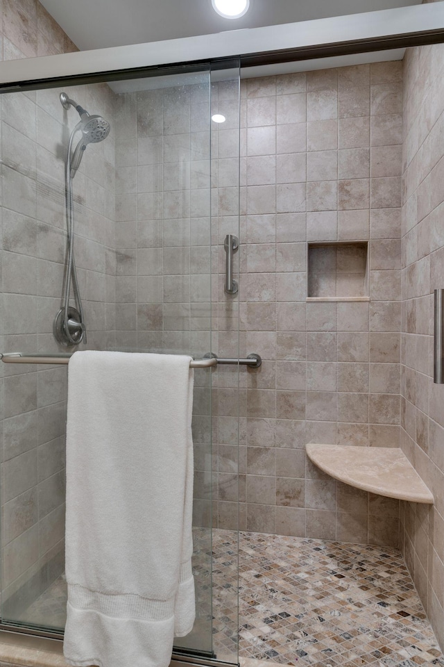 bathroom featuring a shower with shower door