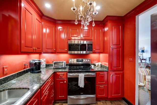 kitchen featuring decorative light fixtures, appliances with stainless steel finishes, dark stone counters, and an inviting chandelier