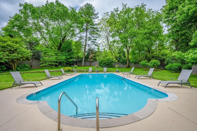 view of pool with a patio area and a yard