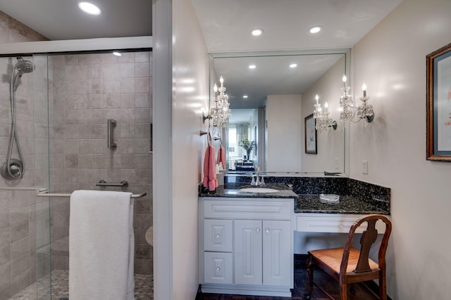 bathroom with a shower with shower door and vanity