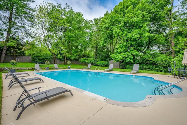 view of pool with a lawn and a patio area