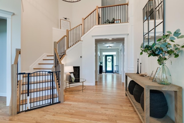 foyer entrance with a towering ceiling and light hardwood / wood-style flooring