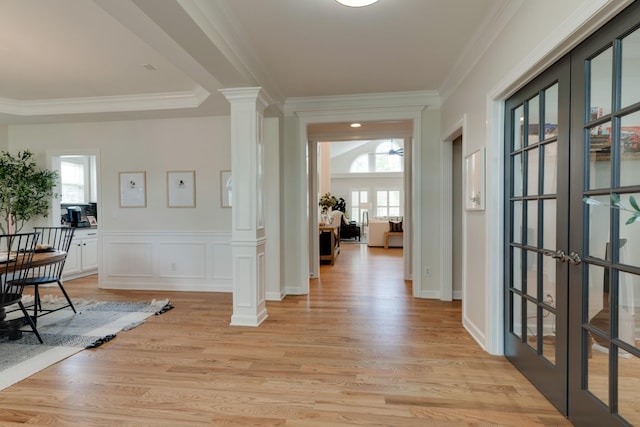 entrance foyer featuring french doors, crown molding, light hardwood / wood-style floors, and ornate columns