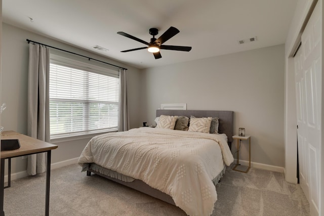 carpeted bedroom featuring ceiling fan and a closet