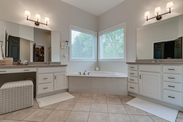 bathroom featuring a tub to relax in, vanity, and tile patterned flooring