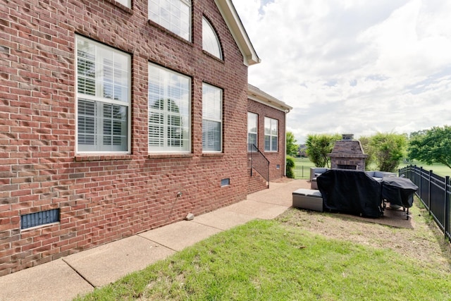 view of property exterior featuring exterior fireplace and a lawn