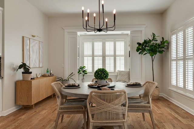 dining room with light hardwood / wood-style flooring and a chandelier