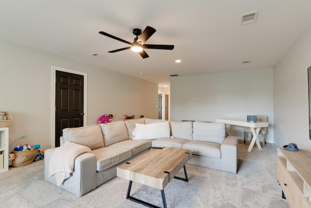 carpeted living room with ceiling fan