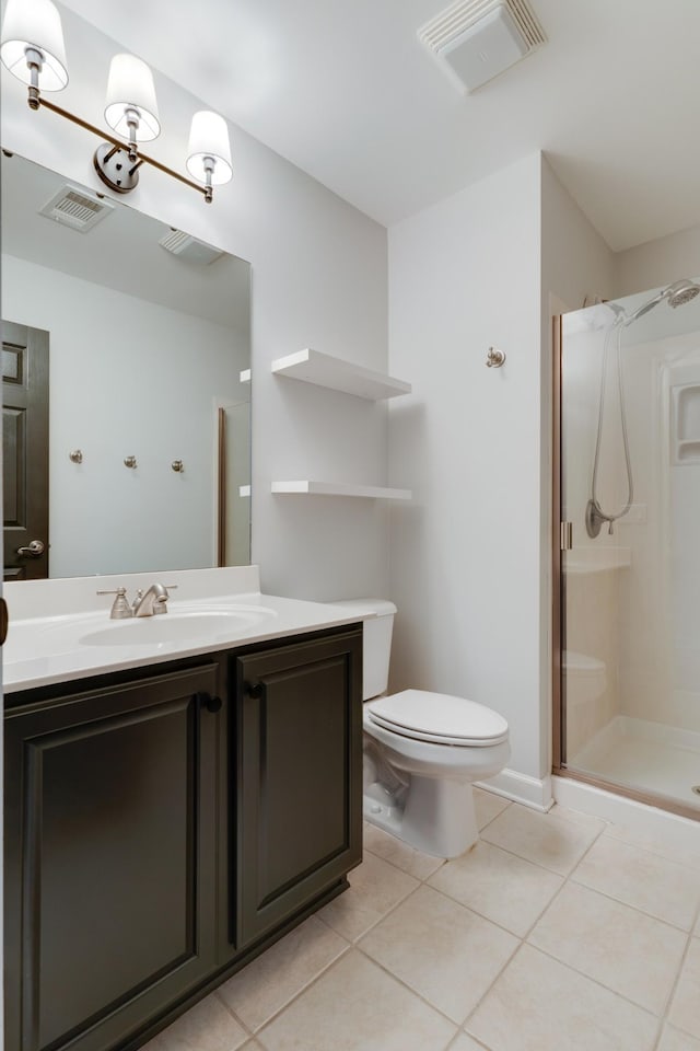 bathroom featuring toilet, vanity, a shower, and tile patterned floors