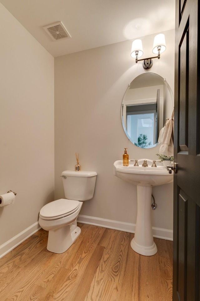 bathroom with toilet and hardwood / wood-style floors