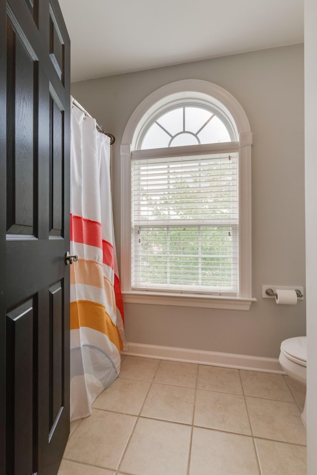 bathroom featuring toilet and tile patterned flooring